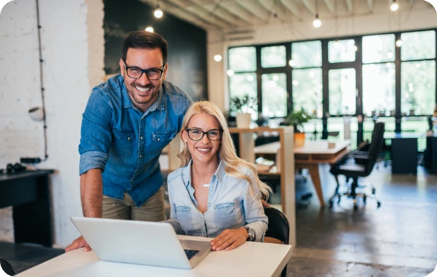 Invincible Pay Direct Deposit, Business owner smiling at computer reviewing payroll dashboard.